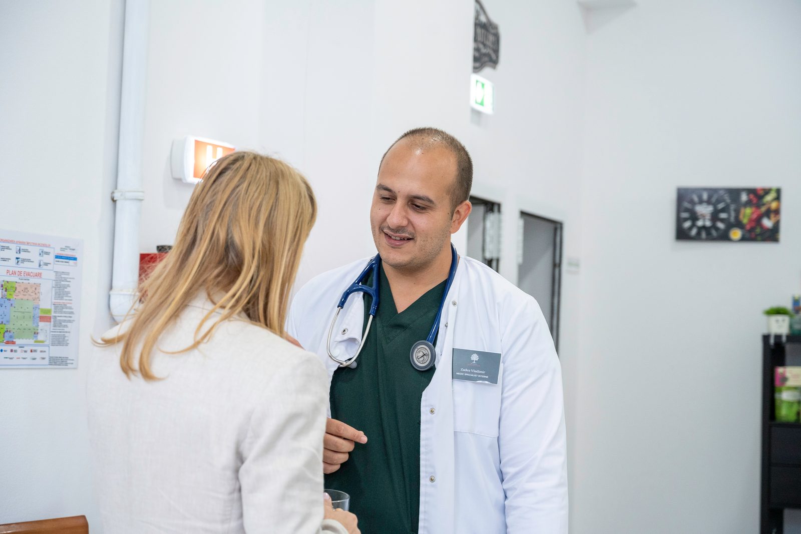 Medic discutând cu o pacientă, în cabinet