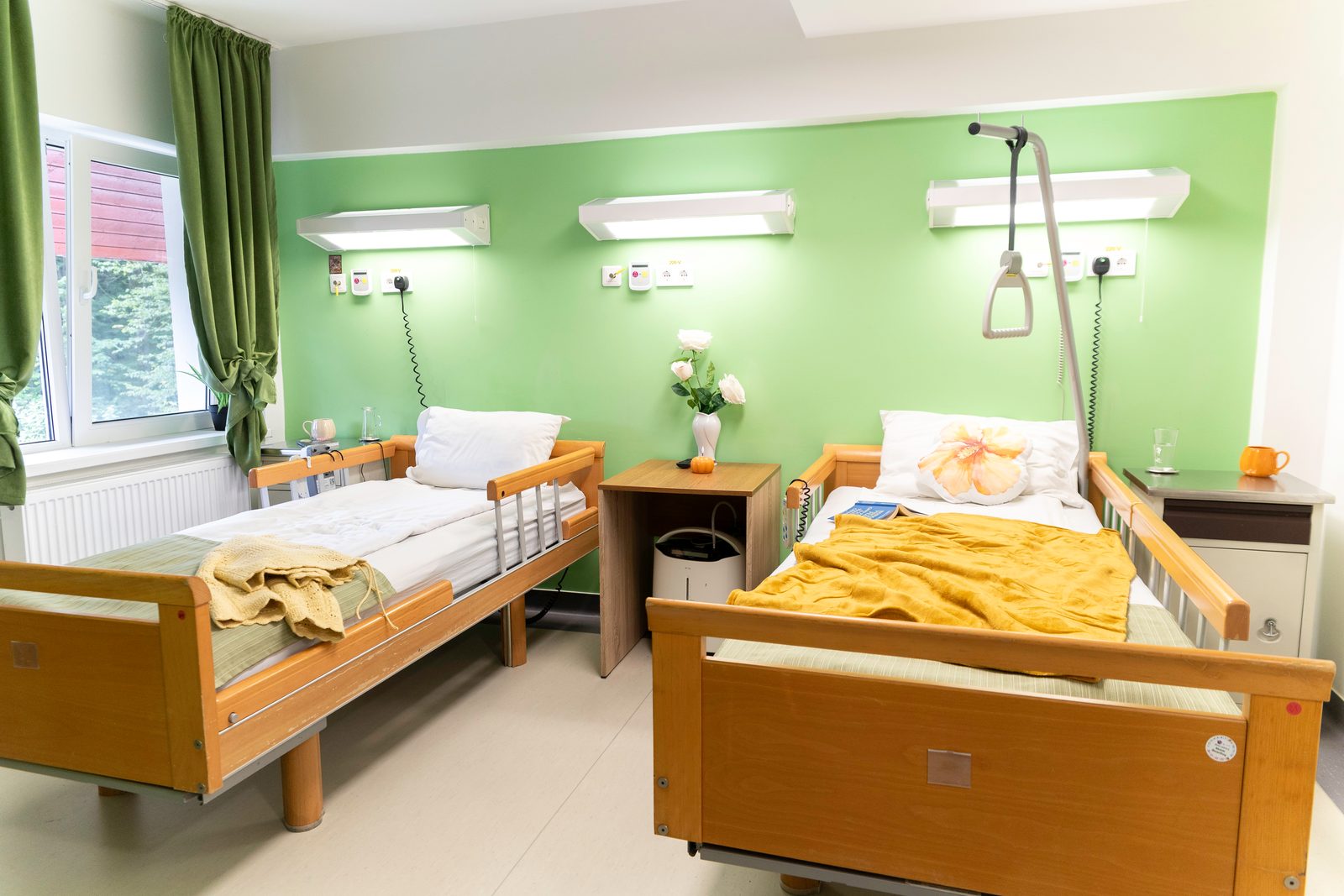 Salon cu două paturi medicale și pereți verzi